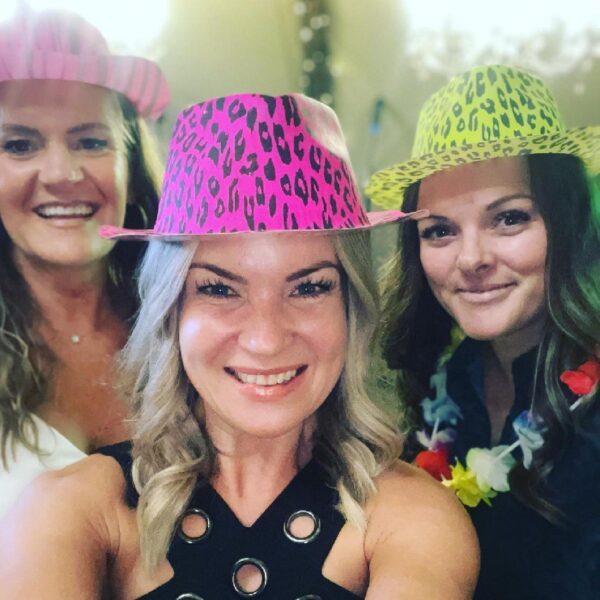 Photo of three of the team members wearing bright party hats